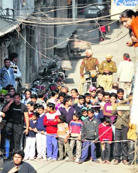 Residents watch the shooting of the film Luv Shuv Tey Chicken Khurana in Ludhiana on Monday