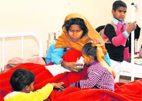 A woman attends to her child at the General Hospital in Mandi Khera village of Nuh (Mewat) district