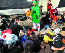 A young girl smeared in blood stands shrieking amid crumpled bodies of dead 