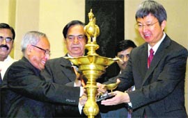 Finance Minister Pranab Mukherjee lights a lamp to inaugurate the 4th Global Conference on Tax and Inequality in New Delhi on Wednesday. IMF Deputy Managing Director Min Zhu (right) is also seen.  PTI