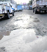 A road stretch in poor condition, with vehicles parked along it, at Industrial Area in Chandigarh