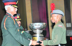 Lt-Gen Manvendra Singh, Commandant, Indian Military Academy, gives away a trophy to a passing out gentleman cadet in Dehradun
