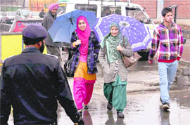 Girls walk with umbrellas in Srinagar on Wednesday