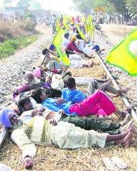 Agitating farmers lie on a railway track near Jethuke village in Bathinda