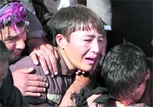 A relative cries near the grave of a victim of Tuesday's bomb attack against Shi'ite Muslims during a funeral ceremony in Kabul on Wednesday