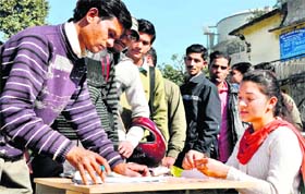 Youths register themselves with representatives of the Spanco company at the Employment Exchange in Dehradun on Thursday