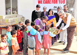 DLF Foundation officials distribute food among poor children at Gurgaon. 