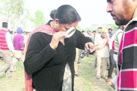 A forensic expert examines a revolver found at the murder spot in Jassowal village on Thursday. 