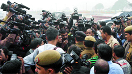 Delhi policemen talk with news cameramen after detaining a photographer at Vijay Chowk in New Delhi on Friday.