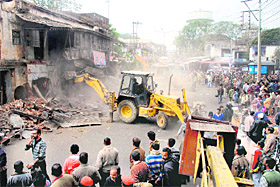A dilapidated building being razed by the Dehradun Municipal Corporation at Tehsil Chowk in Dehradun on Friday.