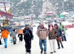 Tourists enjoy the seasons first snowfall in Manali on Friday