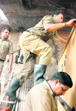 A fireman uses the shoulder of his colleague to scale a wall during a fire-fighting operation in Ludhiana