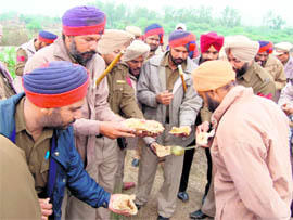 BONHOMIE: Policemen in Beas being served langar by a farmer. 