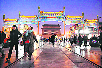 People walk down a shopping street before the Zhengyangmen gate in Beijing on Saturday. Chinas economy lost steam in November as inflation and output slowed sharply, according to data released on Friday, fuelling pressure on Beijing to further relax credit restrictions to prevent a hard landing. 