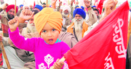 A child joins protesting farmers as they raise anti-government slogans in Beas on Saturday.
