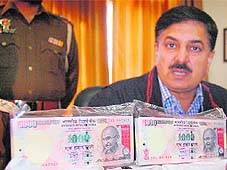 SSP Gurmeet Singh Chauhan shows fake currency and heroin seized in Amritsar on Sunday. 