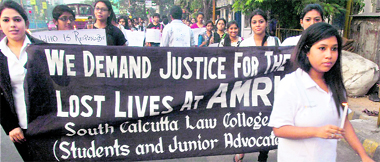College students take part in a candlelight march for the victims of AMRI Hospital fire in Kolkata on Sunday.