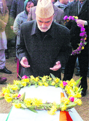 Law and Rural Development Minister Ali Mohammad Sagar pays tribute to the slain constable in Srinagar on Monday.