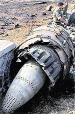IAF personnel carry out an inspection near the debris of a Sukhoi-30 MKI fighter aircraft that crashed soon after taking off from the Lohegaon airbase near Pune on Tuesday. Both pilots managed to bail out safely