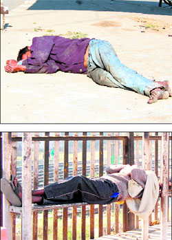 A homeless person lies on the roadside and (below) another uses a park bench to get some sleep under the sun