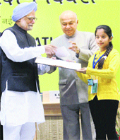 Prime Minister Manmohan Singh presents the third prize of a painting competition to Juicy Sharma, a student from Jammu & Kashmir, at the National Energy Conservation Awards 2011 function in New Delhi on Wednesday. 