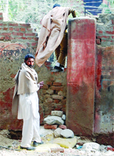 A man scales the broken wall of the Guru Nanak Dev Hospital in Amritsar.