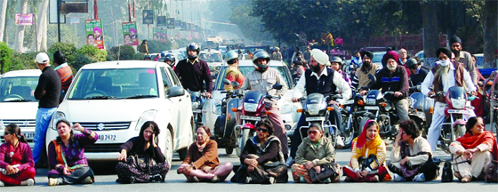 Teachers of government-aided colleges block road at Novelty Chowk in Amritsar on Thursday.