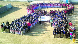 Children stand in the shape of the Red Ribbon symbol during an AIDS awareness camp at Government Senior Secondary School, Harchakyan, Kangra district, on Thursday