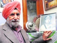 Brigadier Sant Singh (retd) with the portrait of Lt Gen AAK Niazi and his alarm clock which were seized from his office in Dhaka in 1971 after Pakistan troops surrendered.
