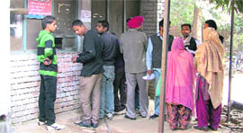 People stand in a queue at a counter of the Suvidha Centre at the Civil Surgeons office in Ludhiana.