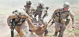 US Marines carry a comrade wounded by an IED to a waiting Medevac helicopter, near the town of Marjah in Helmand Province on August 21, 2010.