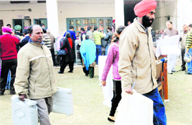 Staff on election duty carry paraphernalia at BEd College in Sector 20, Chandigarh, on Friday.