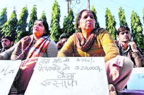 Members of the All-J&K Home Guard Welfare Association hold a protest in support of their demands in Jammu on Friday