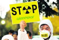 An activist holds a placard against the cold shutdown at Fukushima plant