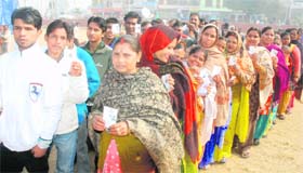 Residents stand in queues to cast their vote at a polling station in Vikas Nagar, Chandigarh, on Saturday