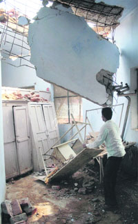 An employee looks at the collapsed roof of the nursess ward