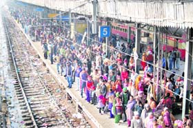 Passengers wait for their respective trains, running late due to fog, on a crowded platform at the railway station in Amritsar