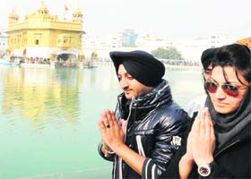 Pakistani film actress Sana Khan (right) and Punjabi singer Inderjit Singh Niku pay obeisance at the Golden Temple in Amritsar on Monday