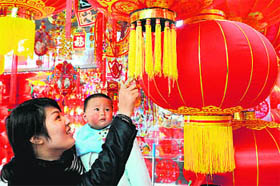 A woman selects red lanterns for the upcoming New Year celebrations in Yiwu, east Chinas Zhejiang province on Monday. Output from China's factories and workshops rose at the slowest pace in over two years in November, data showed in December, as turbulence in Europe and the US hit demand for Chinese exports.