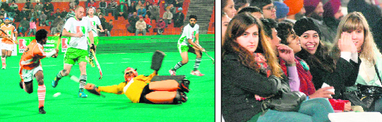 Players in action during the hockey exhibition match at Hockey Stadium, Sector 42, Chandigarh, on Tuesday and (right) foreigners enjoy the hockey match between World XI and India XI. 