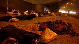 Homeless people sleep under an overbridge near Sarai Kale Khan.