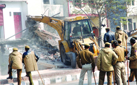 MCD workers and Delhi policemen during a demolition drive at Gandhi Nagar Market in New Delhi on Tuesday.