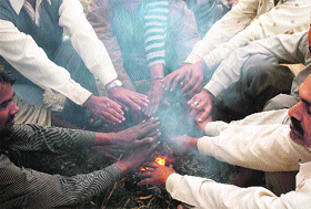 With the mercury nosediving, people warms themselves around a bonfire in Gurgaon on Tuesday.