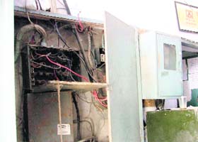Naked wires hang out of an electricity panel at the Civil Surgeon’s Office