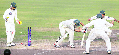 Bangladesh's Nazimuddin (C) is bowled as Pakistan's wicketkeeper Adnan Akmal (L) watches in Dhaka on Tuesday.
