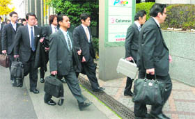 Investigators walk into a Tokyo office building that houses three Olympus subsidiaries. Japanese prosecutors raided Olympus Corp offices and the homes of former executives on Wednesday over a $1.7 billion accounting scandal that has threatened the survival of the once-proud camera and medical equipment maker 