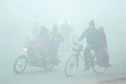 People go about their business despite the fog and chill that the city witnessed on Wednesday morning
