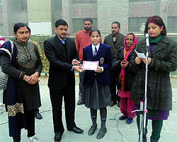 A student receives her award at a painting competition organised by the SBI Life Insurance Company at the Police Public School in Bathinda