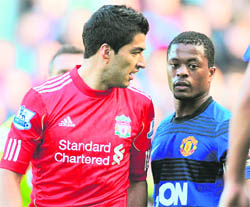 A file phot of Liverpool's Uruguayan forward Luis Suarez (L) exchanging words with Manchester United's French defender Patrice Evra during their match in Manchester.  AFP