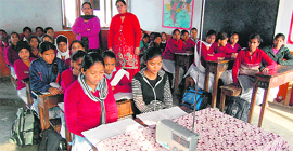Students of a government elementary school learn their lessons by listening to the radio in Amritsar.